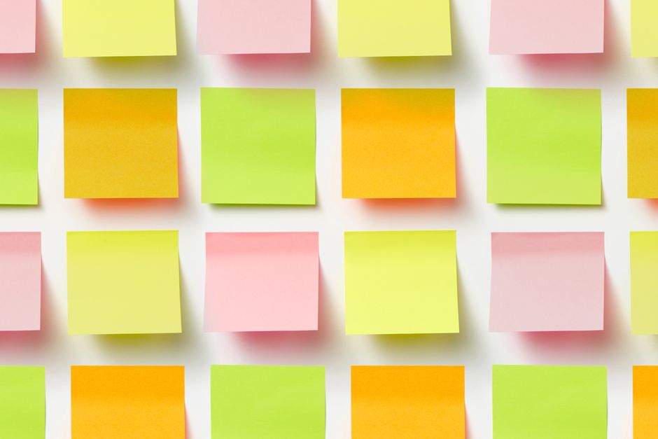Des notes autocollantes colorées disposées en grille sur un fond blanc, prêtes à accueillir des messages doux.