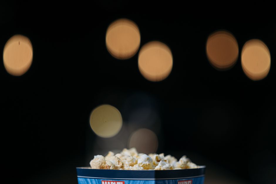 Bol de popcorn sur fond flou avec des lumières, évoquant une ambiance de cinéma maison.
