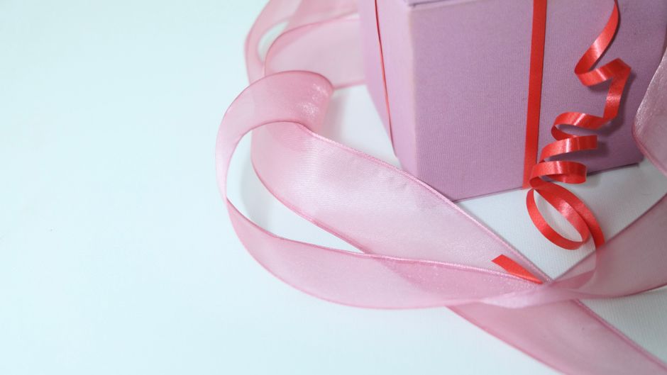 Cadeau emballé en rose avec un ruban rouge, symbolisant la réconciliation après une dispute.