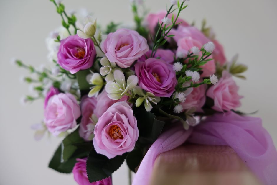 Bouquet de roses roses et blanches avec un ruban violet, symbolisant l'amour et la romance.