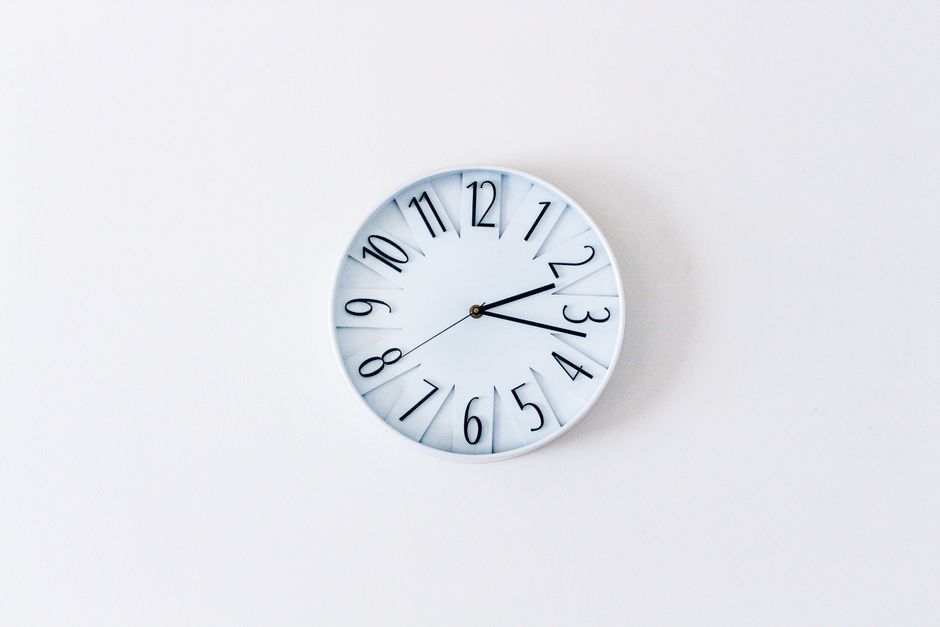 Horloge murale blanche indiquant l'heure, symbolisant l'urgence des cadeaux de dernière minute.