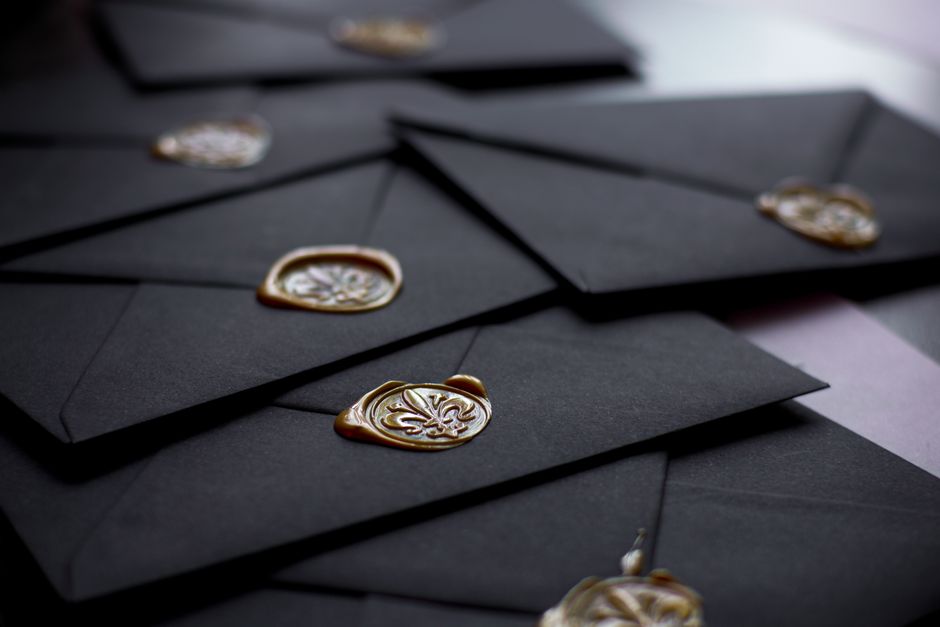 Enveloppes noires scellées avec de la cire dorée, prêtes à être envoyées pour des messages surprises.