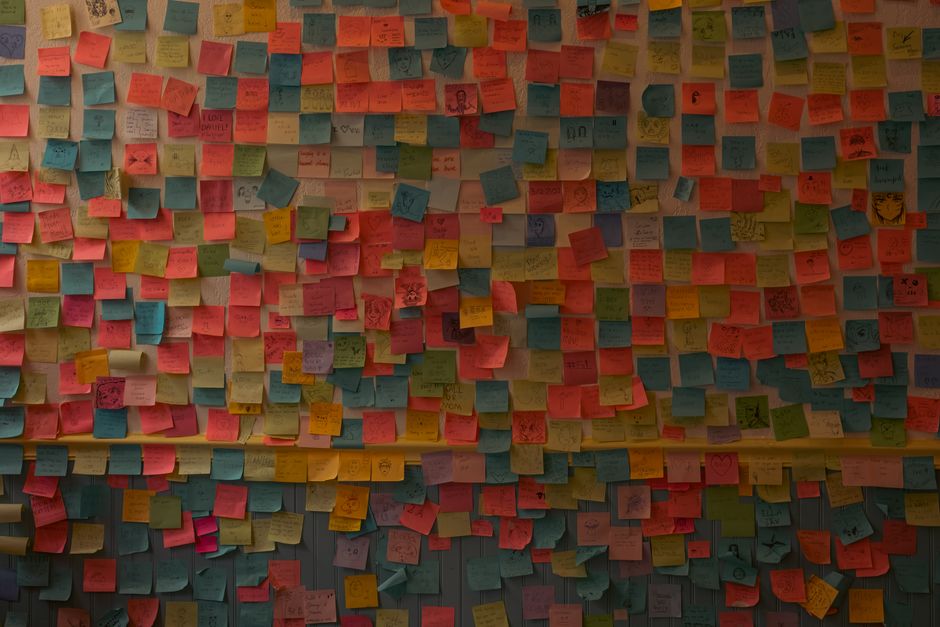 Mur recouvert de notes autocollantes colorées, créant une ambiance ludique pour une chasse au trésor à la maison.