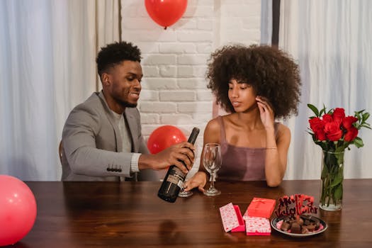 Un couple partage un moment romantique à table, avec du vin, des fleurs et des cadeaux pour la Saint-Valentin.
