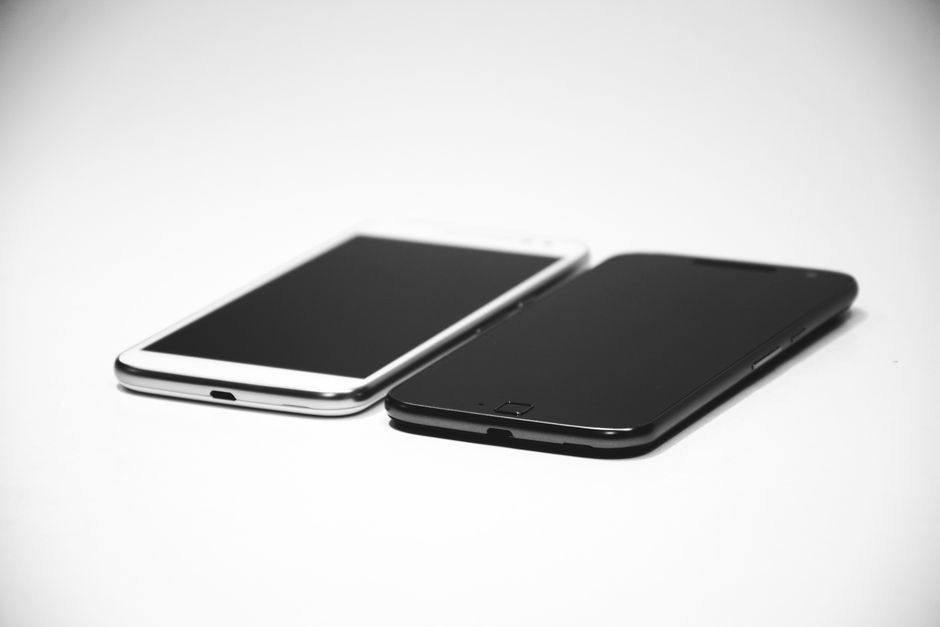 Deux smartphones posés sur une surface blanche, l'un blanc et l'autre noir, prêts à diffuser de la musique romantique.