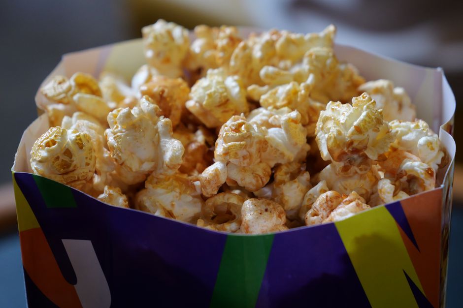 Un grand bol de popcorn doré, prêt pour une soirée cinéma chic à la maison.