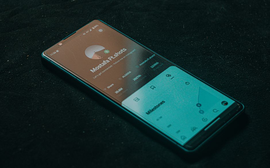 Téléphone posé sur une surface sombre affichant une playlist de chansons d'amour pour un dîner romantique.